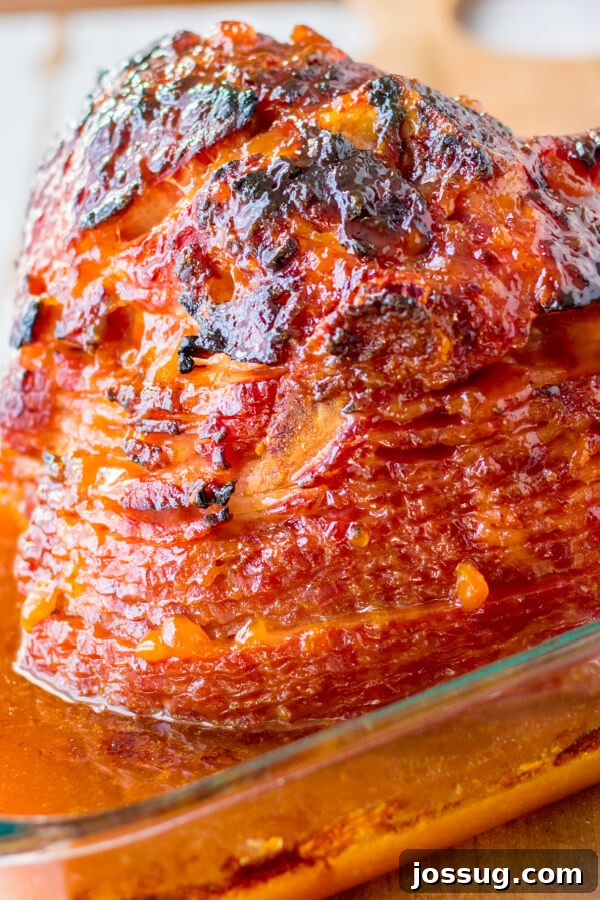The Apricot Dijon Spiral Ham, perfectly baked with a glossy, caramelized crust, resting in the roasting pan after being removed from the oven.