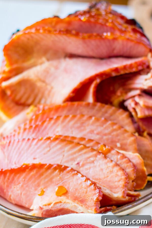 A platter with slices of Apricot Dijon Spiral Ham, perfectly carved and arranged, ready for serving.
