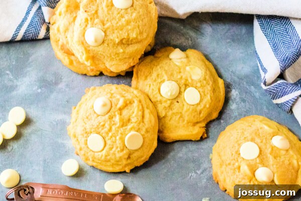 Bright Lemon Cloud Cookies 5 Several soft and chewy lemon pudding cookies arranged artfully on a blue background, some with a hint of powdered sugar, emphasizing their inviting texture and bright color.