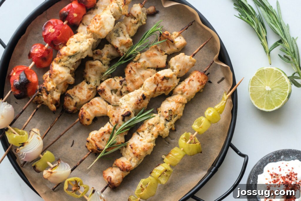 Beautifully arranged food on a serving tray, including chicken skewers and fresh salad.