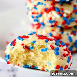 closeup of a sprinkle cookie with a bite taken out to show the inside texture