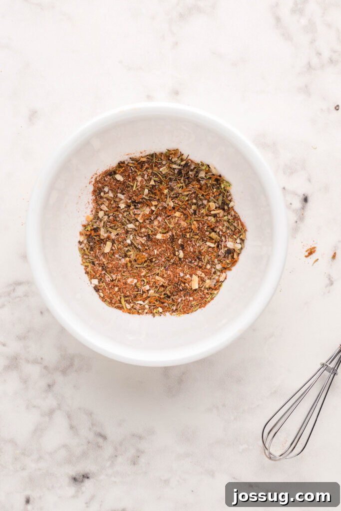 Cajun Blackened Seasoning 3 A vibrant blend of blackened seasoning expertly mixed in a pristine white bowl, showcasing its rich colors and inviting texture.