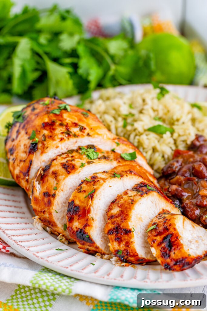 Sliced Air Fryer Margarita Chicken on a plate with rice and beans