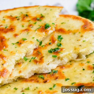 Close-up of a perfectly cooked, torn flatbread, highlighting its soft interior with fresh herbs.
