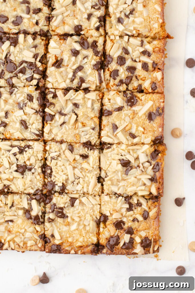 Miracle Layered Dessert Bars 3 A tray of freshly baked Magic Cookie Bars, perfectly cut into squares, showcasing the golden-brown top and rich layers within.
