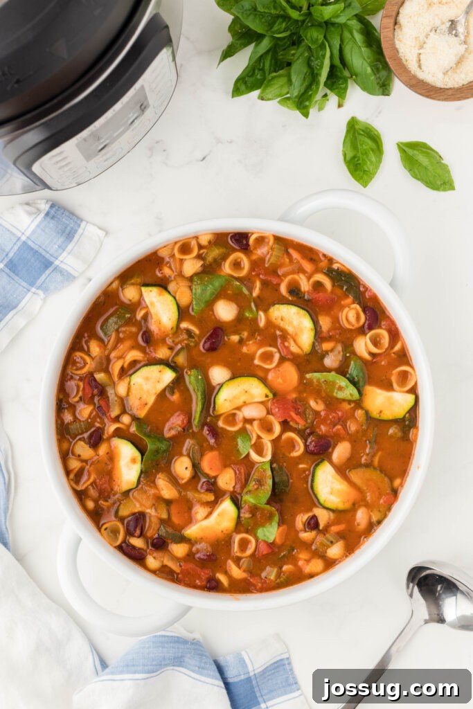 A close-up shot of a vibrant bowl of Instant Pot Minestrone Soup, showcasing the medley of vegetables, beans, and pasta.