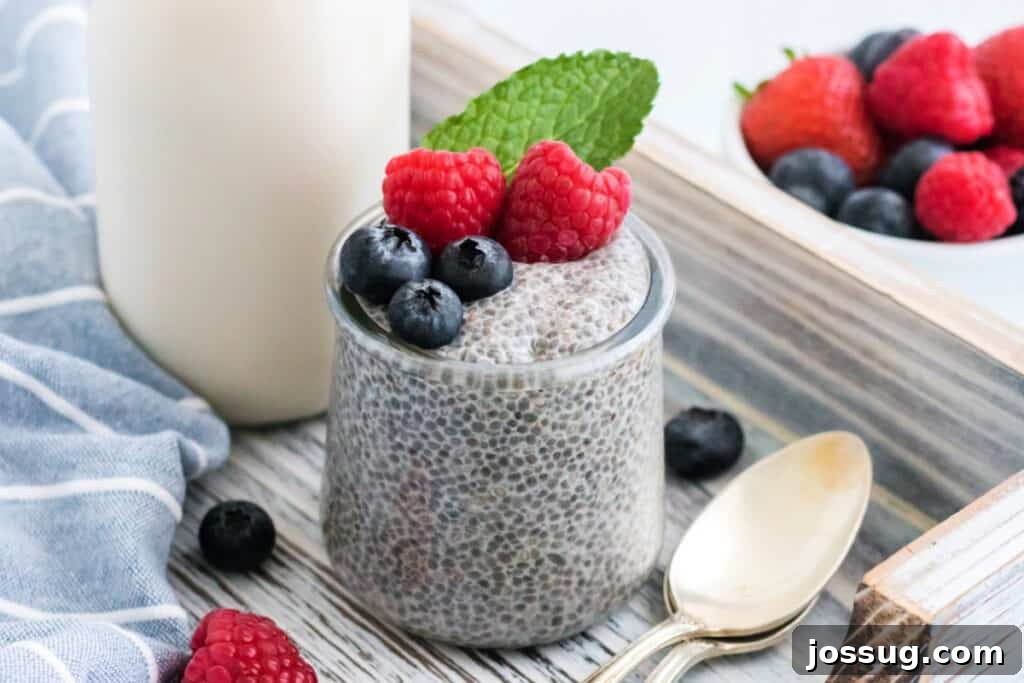 A beautifully arranged glass jar of chia seed pudding topped with an array of fresh berries.