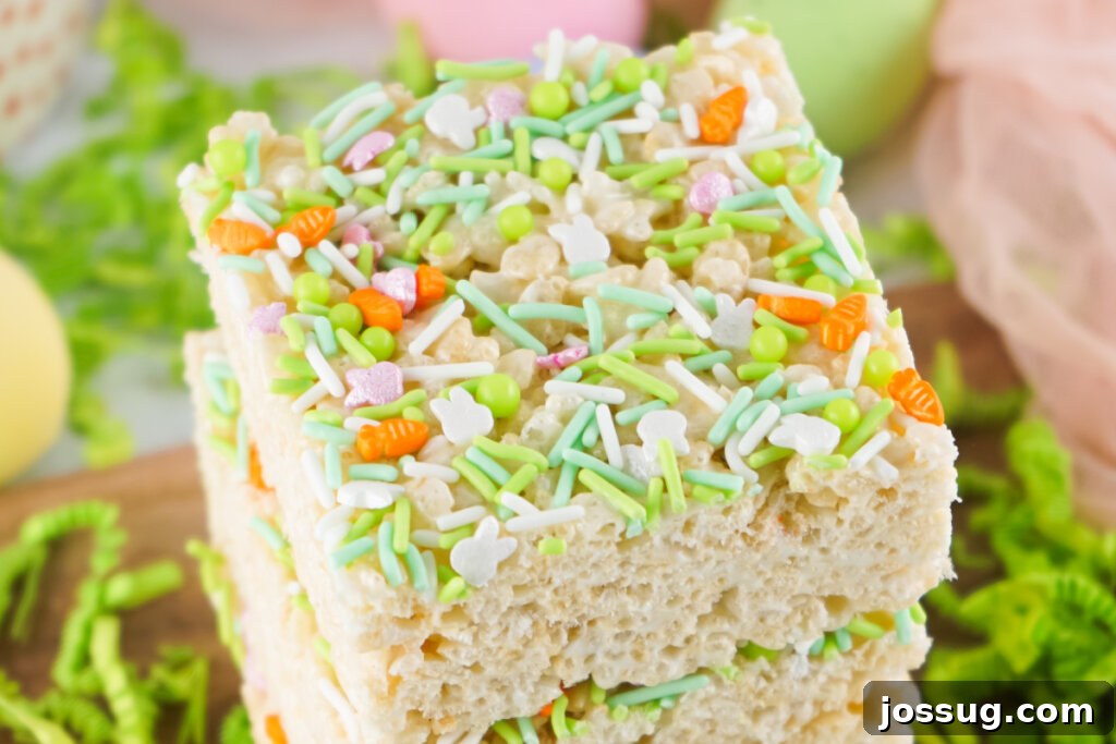 A close-up of perfectly cut and stacked Easter Rice Crispy Treats, highlighting their soft texture and colorful decorations.