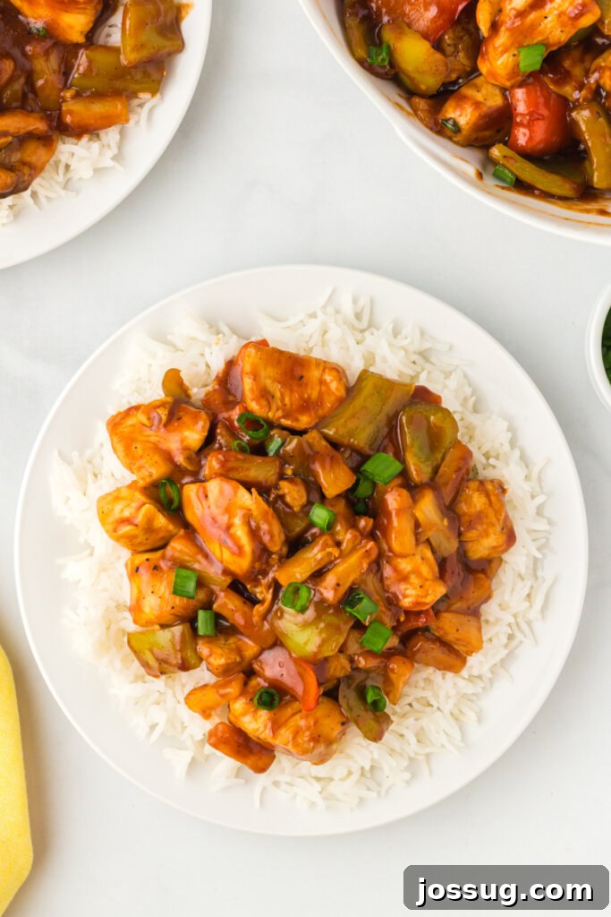 Delicious Hawaiian Chicken served over fluffy white rice, garnished with green onions and pineapple chunks.