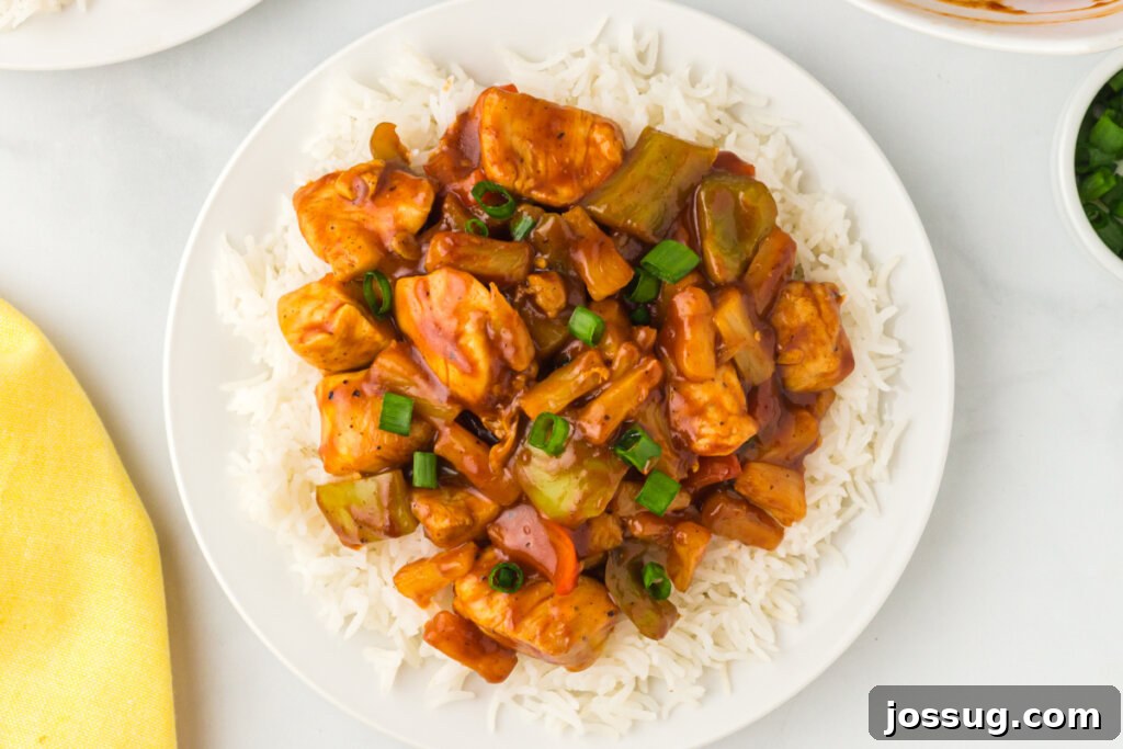 A beautifully plated serving of Hawaiian Chicken with rice, showcasing the sweet and savory sauce, fresh pineapple, and tender chicken.
