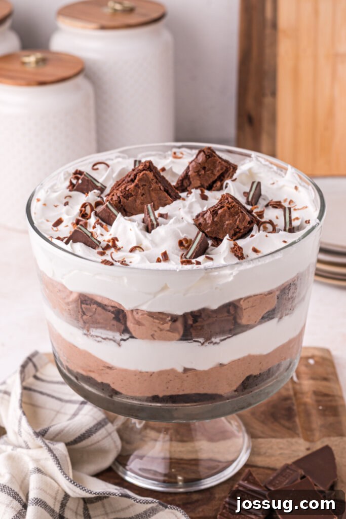Layered Chocolate Brownie Indulgence 2 Decadent brownie trifle in a clear glass bowl, showcasing its beautiful layers of chocolate brownies, creamy pudding, and fluffy whipped topping.