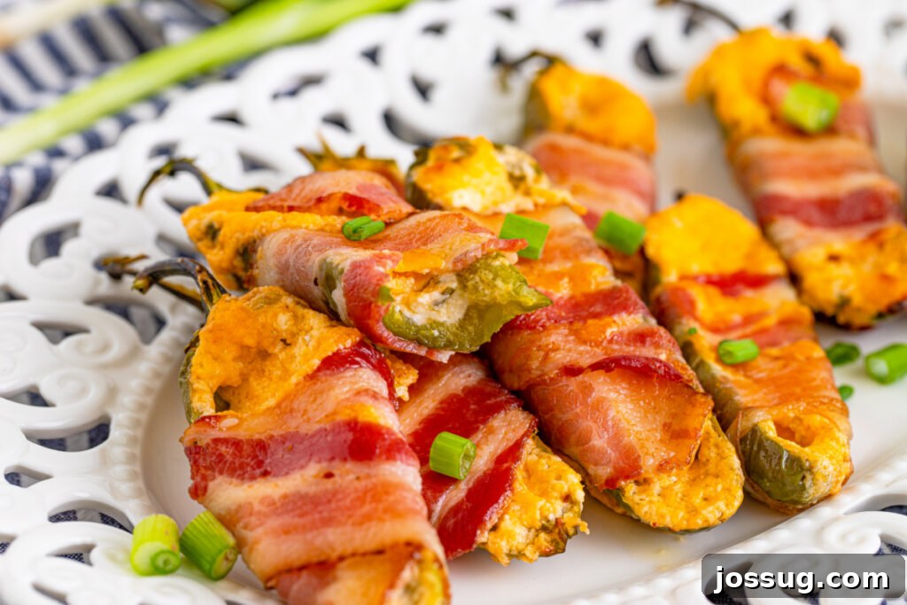 A platter of cooked, golden-brown bacon-wrapped jalapeno poppers, ready to be enjoyed