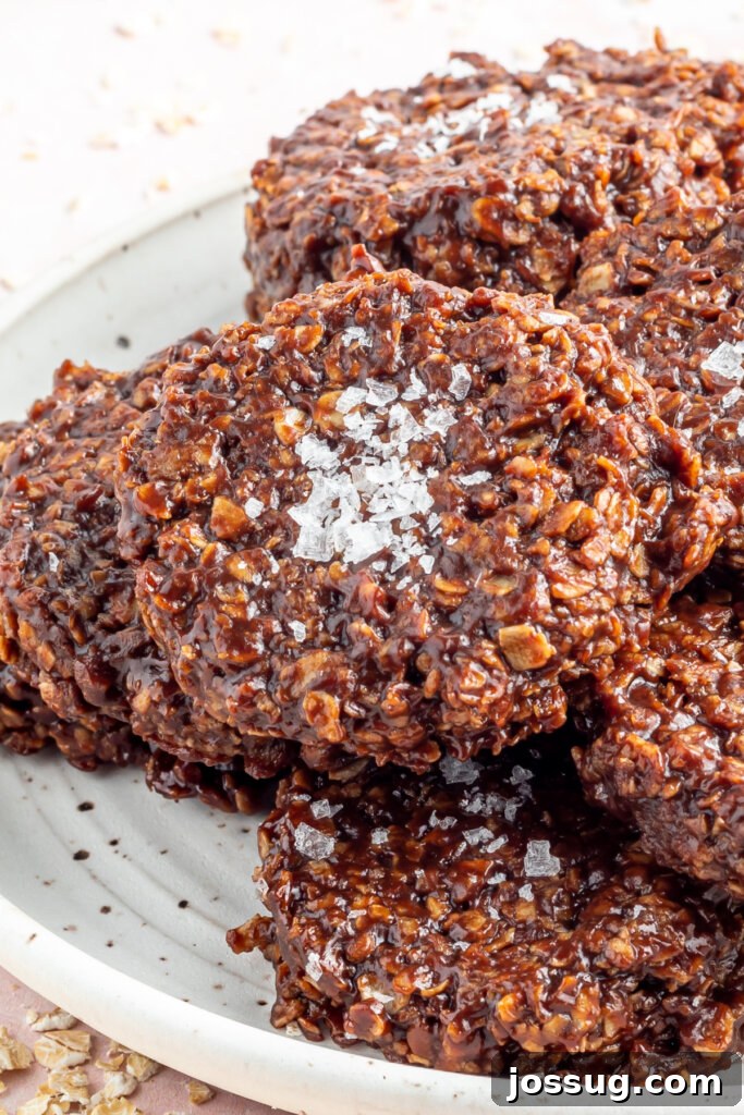 Stacked Salted Almond Butter No-Bake Cookies on a plate, highlighting their rich chocolatey texture and a sprinkle of sea salt.