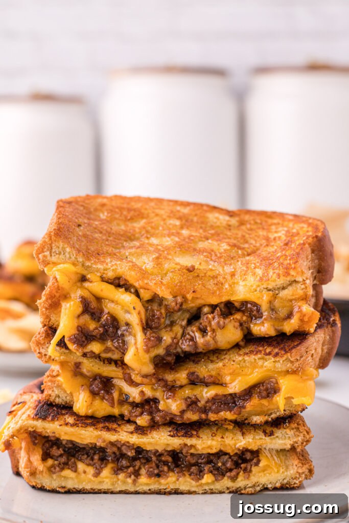 Sloppy Joe Meltdown 2 Two halves of a Sloppy Joe Grilled Cheese sandwich stacked, showcasing the hearty filling and melted cheese.