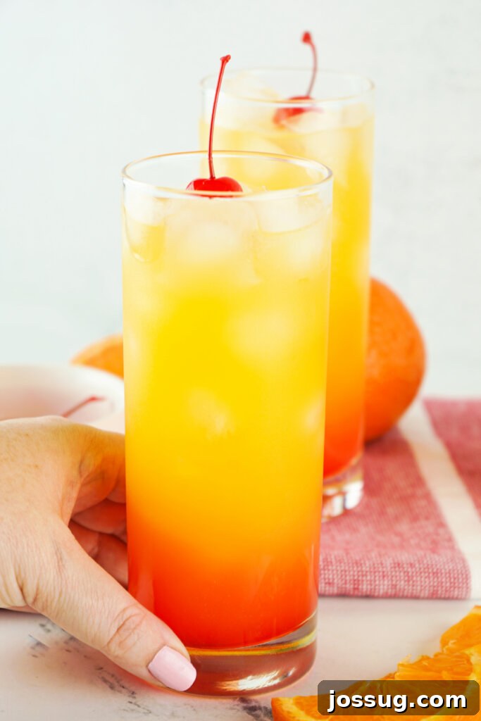 Golden Sunrise Tequila 4 hand holding a tequila sunrise cocktail