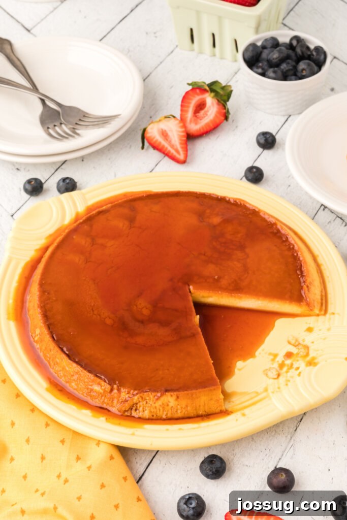 Velvety Caramel Flan 3 A whole Spanish flan on a plate with a perfect slice removed, showing the creamy texture and caramel.