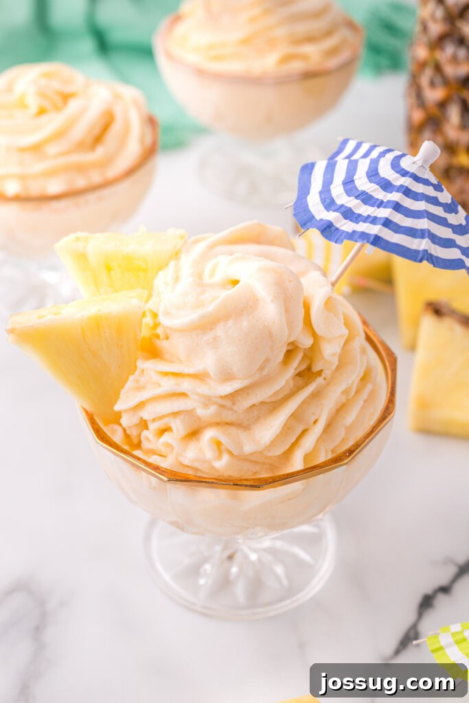 copycat disney dole whip with pineapple wedges and small drink umbrella, ready to serve