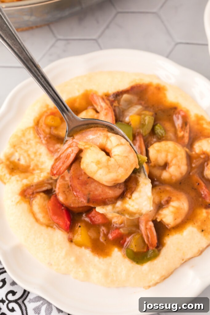 Carolina's Signature Shrimp and Grits 5 A serving spoon lifting a portion of shrimp and grits, showcasing the perfect balance of creamy grits and the rich shrimp mixture.