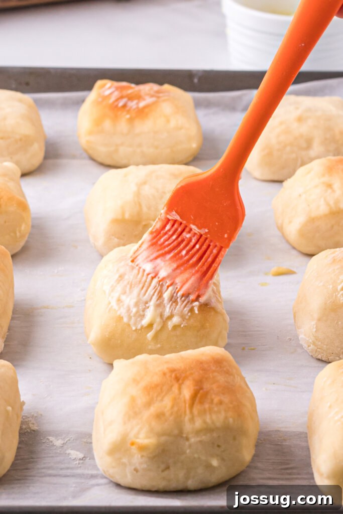 baked roll being brushed with butter