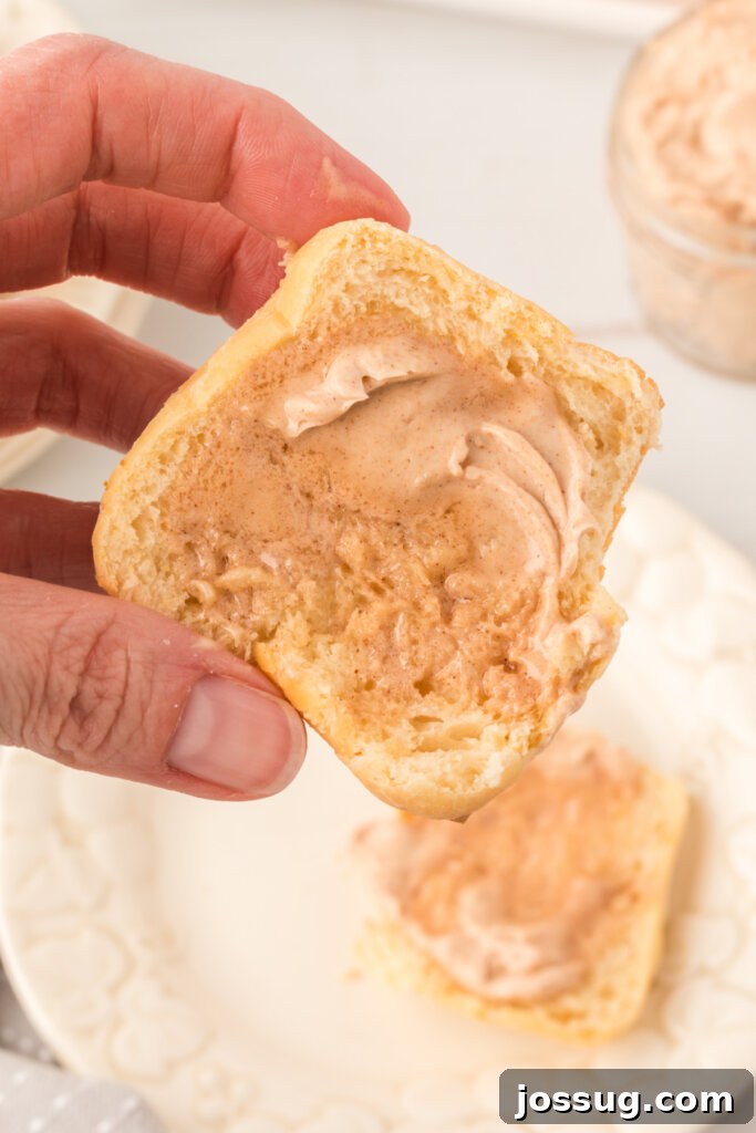hand holding a copycat texas roadhouse roll spread with cinnamon butter