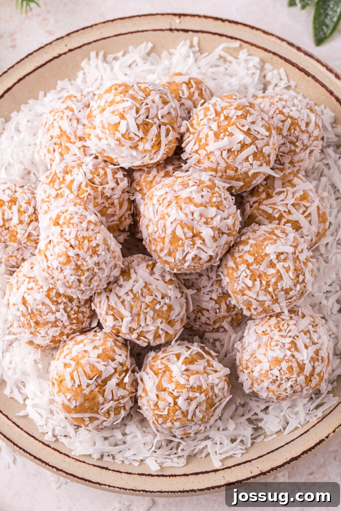 Coconut Bliss Bites 4 Looking down onto a white plate generously filled with perfect no-bake coconut snowballs