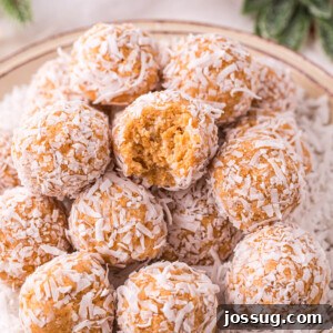 coconut snowballs stacked on plate with bite taken out of one snowball