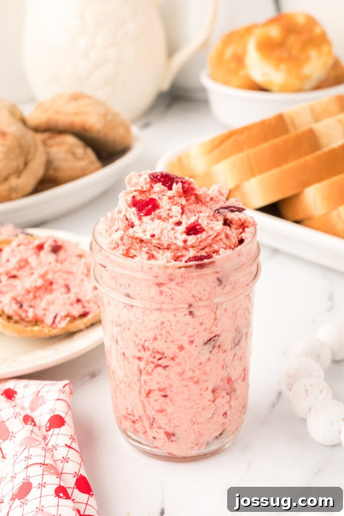Crimson Cranberry Cloud Butter 2 Whipped cranberry butter in a clear glass jar, showcasing its beautiful pink hue and creamy texture.