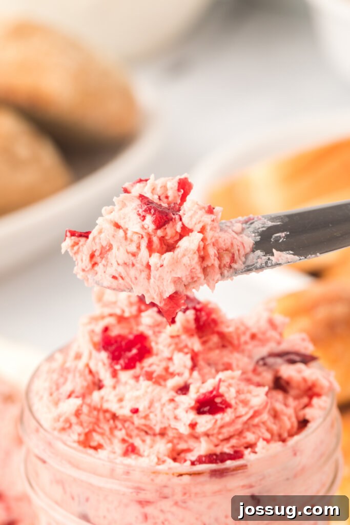 Crimson Cranberry Cloud Butter 3 A knife delicately spreading whipped cranberry butter, showing its smooth texture.