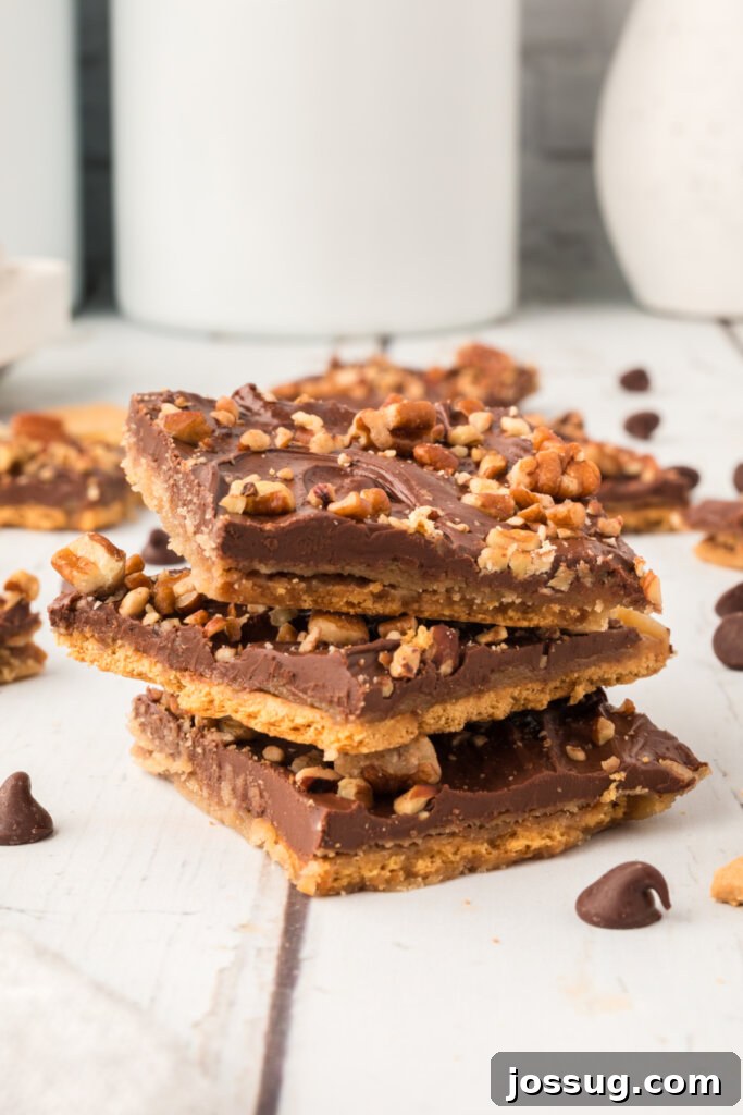 three pieces of graham cracker toffee stacked on a white plate