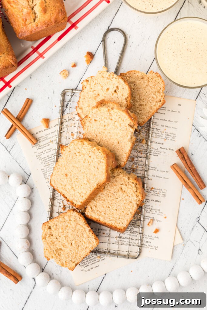 Several slices of Holiday Eggnog Bread meticulously arranged on a wire cooling rack, showcasing their golden-brown crust, tender interior, and the perfect bake.