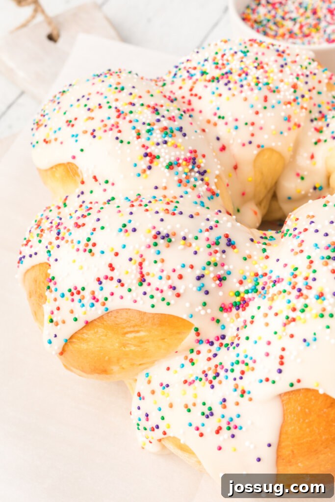 A close-up view of a beautifully braided loaf of frosted Italian anise bread, highlighting the intricate twist and inviting glaze.