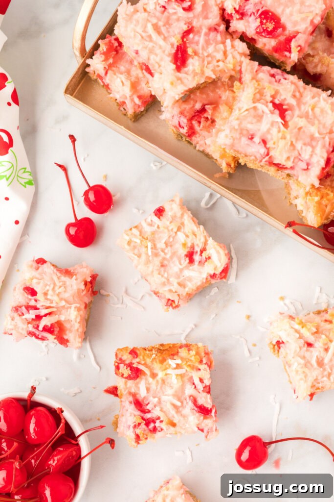 Overhead view of a tray of freshly baked Cherry Coconut Magic Bars on a table.