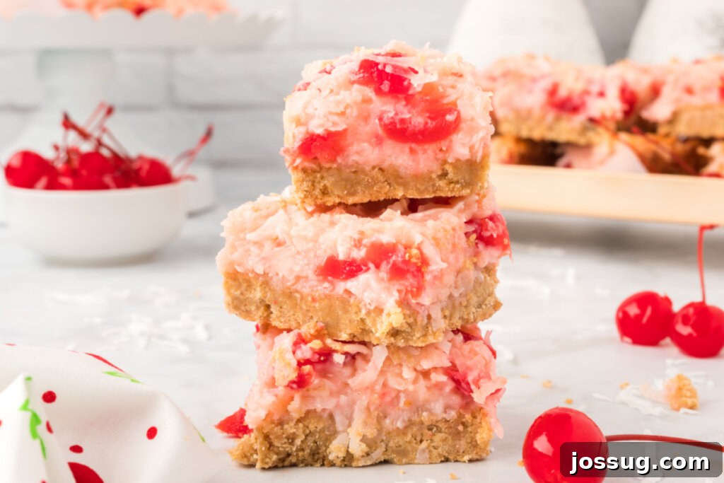A stack of golden Cherry Coconut Magic Bars with red cherry bits visible.