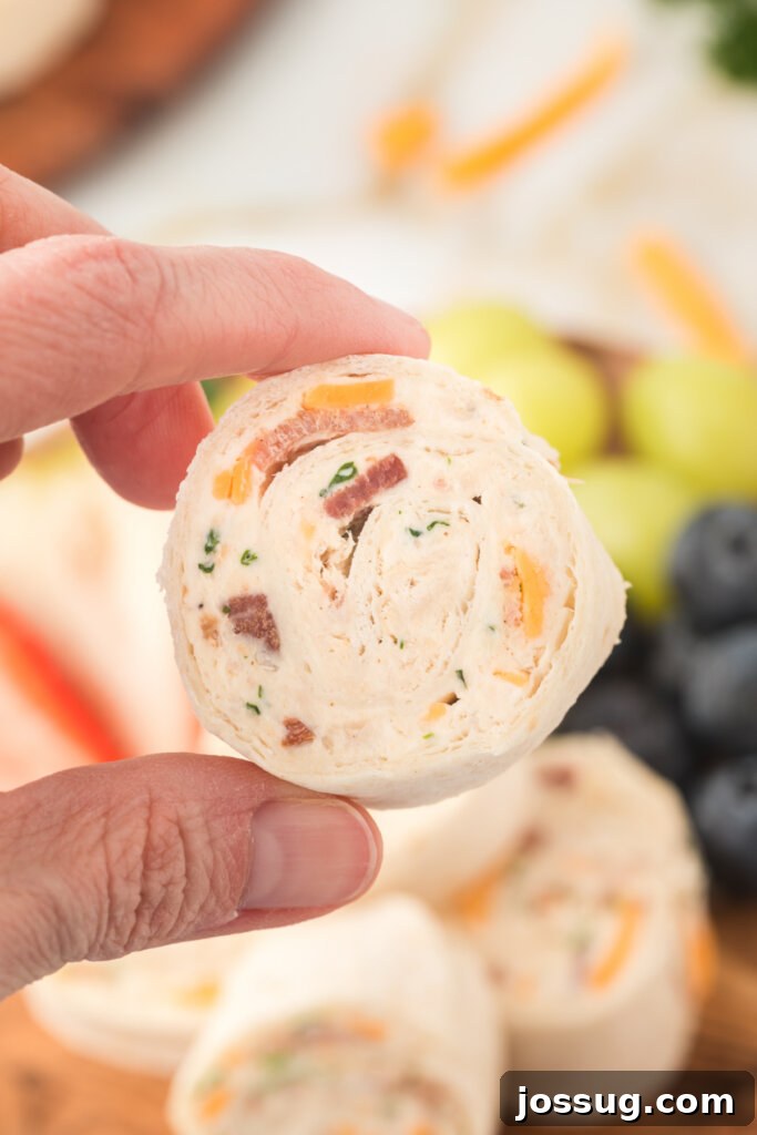 Creamy Chicken Bacon Ranch Pinwheels 4 hand holding chicken pinwheel