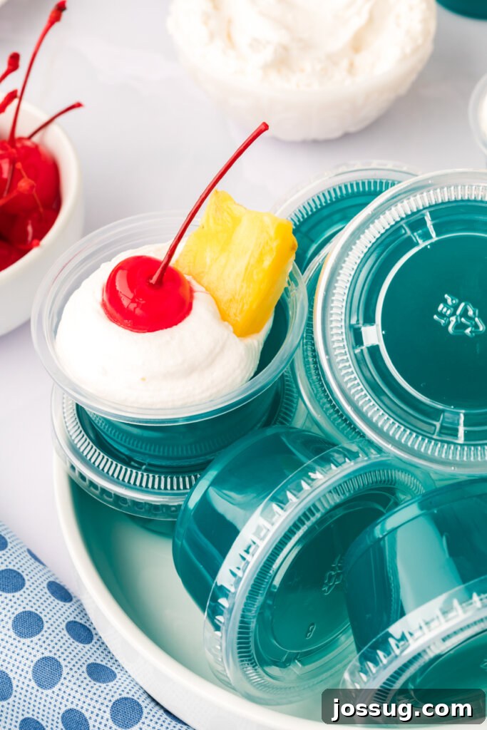 Aloha Glow Gels 4 A clear bowl filled with numerous finished Blue Hawaiian jello shots, ready for a party.