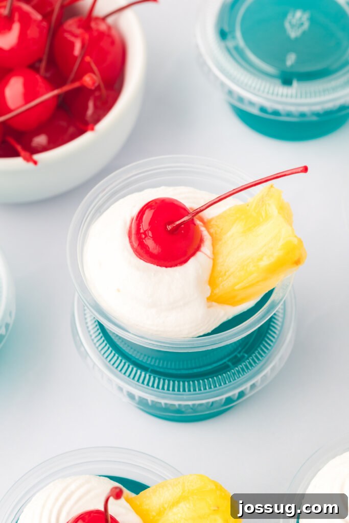 Aloha Glow Gels 5 A close-up, top-down view of a single, perfectly set Blue Hawaiian jello shot, showcasing its vibrant blue color and smooth texture.
