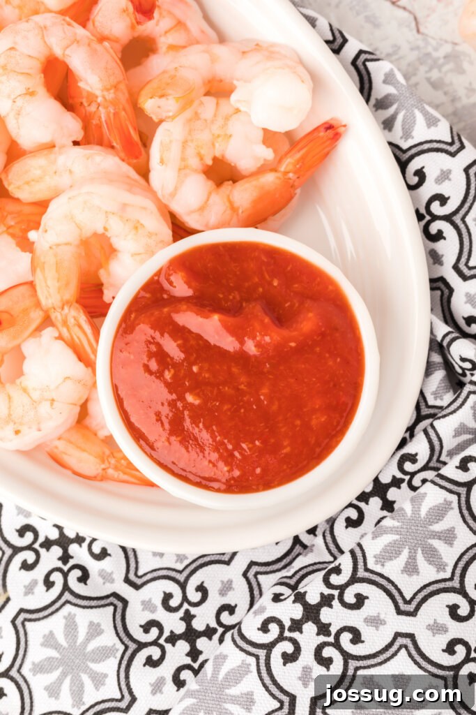 shrimp cocktail sauce and chilled shrimp on white plate