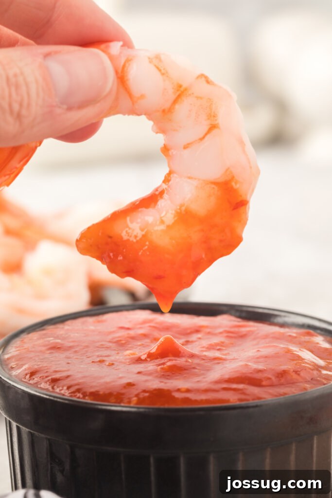 closeup of shrimp being dunked into shrimp cocktail sauce