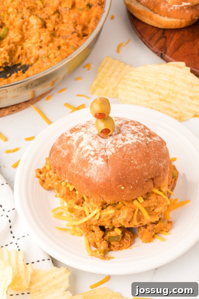 Golden Cheesy Sloppy Joes 5 Four delicious Cheesy Sloppy Joes arranged neatly on a white plate, showcasing the golden-brown buns and the hearty, cheesy filling.