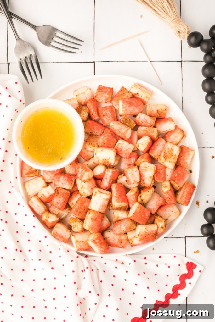 Crispy golden Air Fryer Crab Bites arranged on a serving plate with a side of rich garlic butter dipping sauce