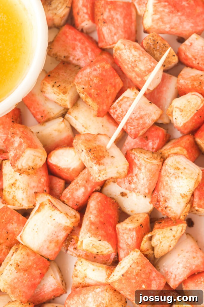 A single air fryer crab bite perfectly impaled on a toothpick, highlighting its crispy texture.