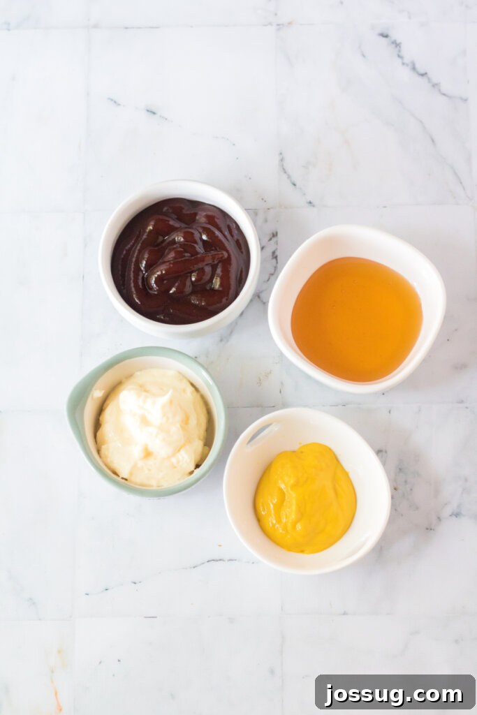 Individual ingredients for Chick-fil-A sauce arranged in small bowls: mayonnaise, honey, barbecue sauce, and yellow mustard.