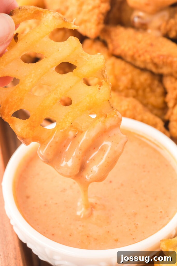 Make Your Own Chick-fil-A Honey Roasted BBQ Sauce 4 closeup of a waffle fry being dipped into honey roasted bbq sauce