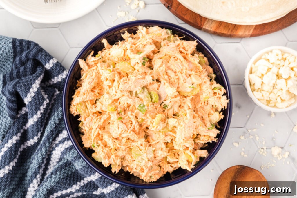 looking down onto a serving of buffalo chicken salad in a bowl with a fork