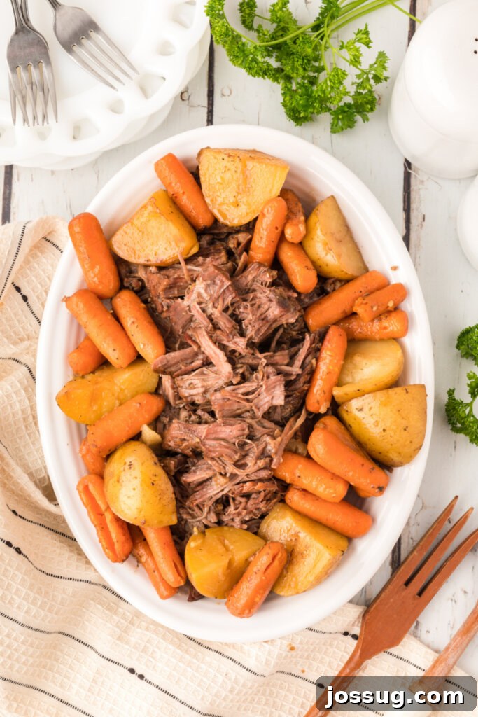 Timeless Pot Roast 2 Serving platter with generously portioned pot roast, tender potatoes, and sweet carrots, glistening with rich gravy.
