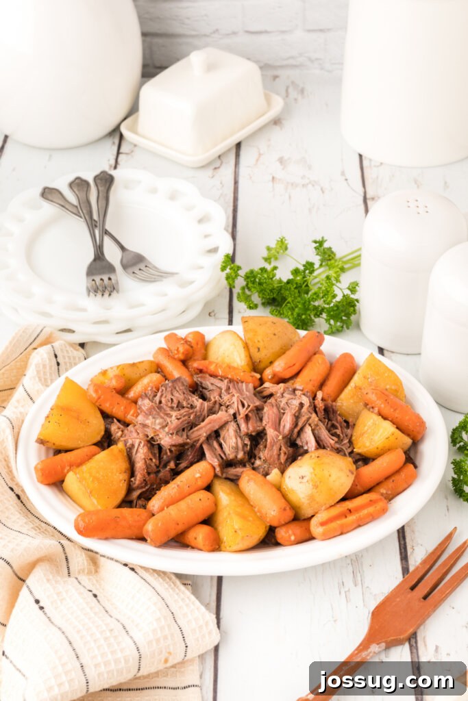 Timeless Pot Roast 4 Platter showcasing a perfectly cooked old-fashioned pot roast, surrounded by tender Yukon gold potatoes and bright orange carrots, ready for serving.