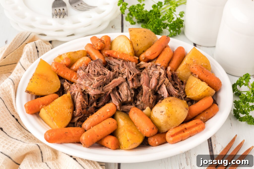 Timeless Pot Roast 6 Large serving platter overflowing with the completed pot roast, featuring succulent beef, soft potatoes, and vibrant carrots, drizzled with gravy.