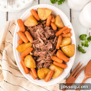 Pot roast with carrots and potatoes on platter, served family style.