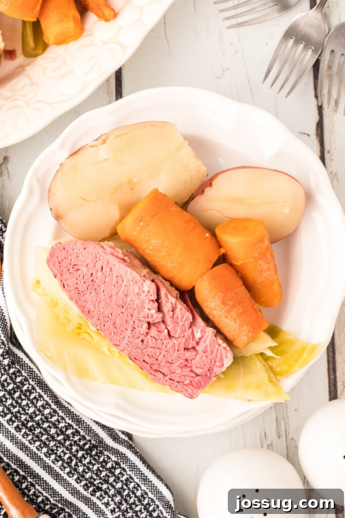 A beautifully plated serving of Corned Beef, Cabbage, Potatoes, and Carrots, showcasing the vibrant colors and hearty portions of this traditional meal.