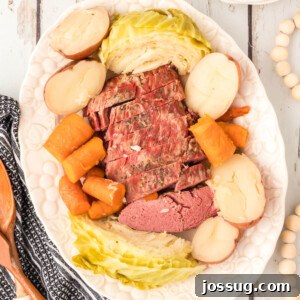 A captivating overhead shot of a platter showcasing perfectly cooked corned beef, tender cabbage, golden potatoes, and vibrant carrots, artfully arranged for serving.